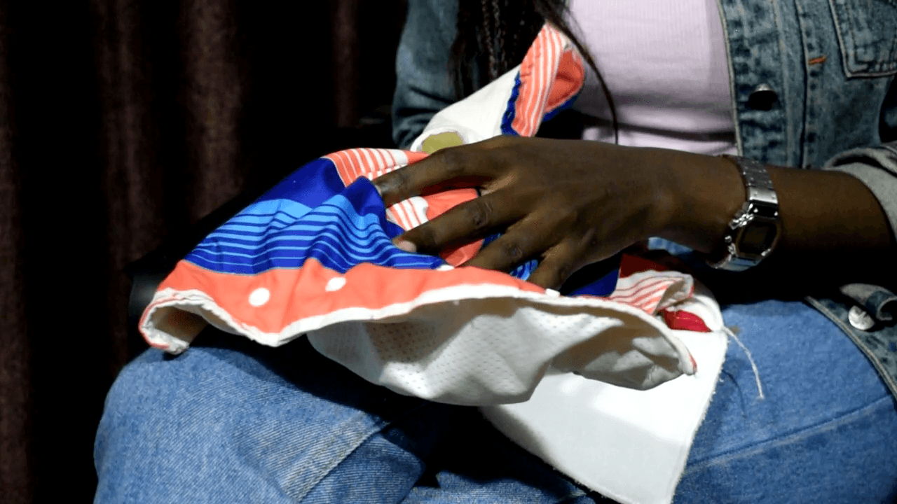 Single mother making reusable pads for teen mothers in Africa